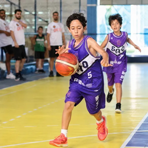 Atleta do CDB conduzindo a bola em jogo de basquete